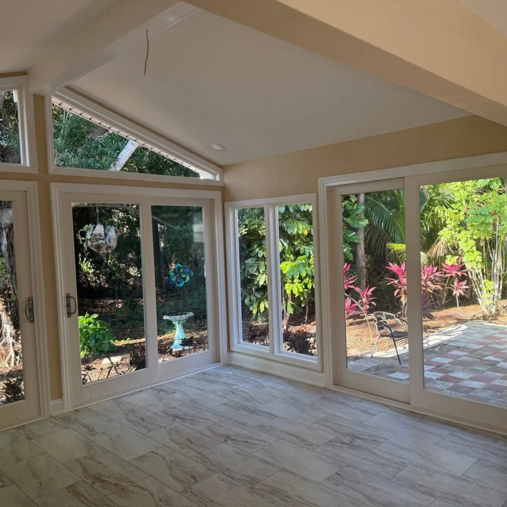 Beige and white all season room with glass sliding doors and windows installed by Regalbuto Contractors