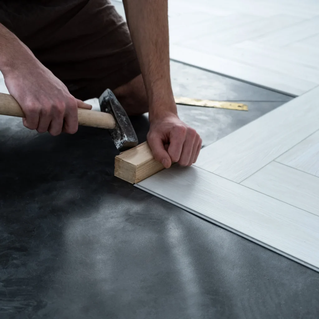 Worker laying quartz flooring as part of a floor renovation