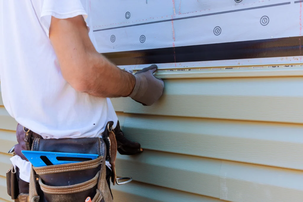 Worker installing siding representing Regalbuto Contractors exterior services