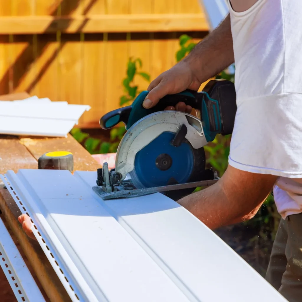 Worker adjusting the dimensions of a siding panel using a saw